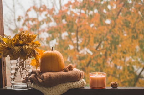 warm indoors during fall season with a pumpkin, candle, and autumn colors